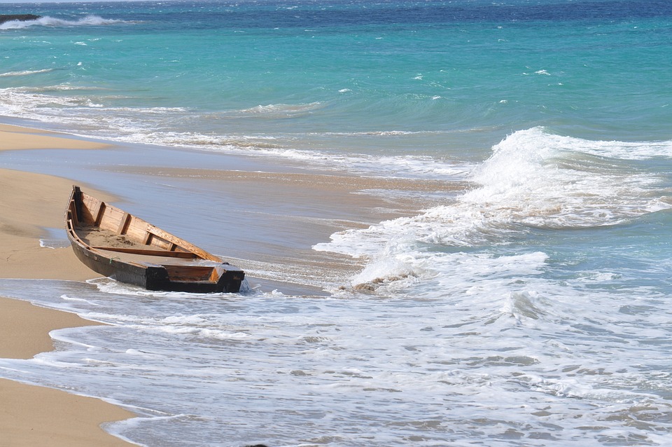 Strand mit einem schiffbrüchig gewordenem Boot